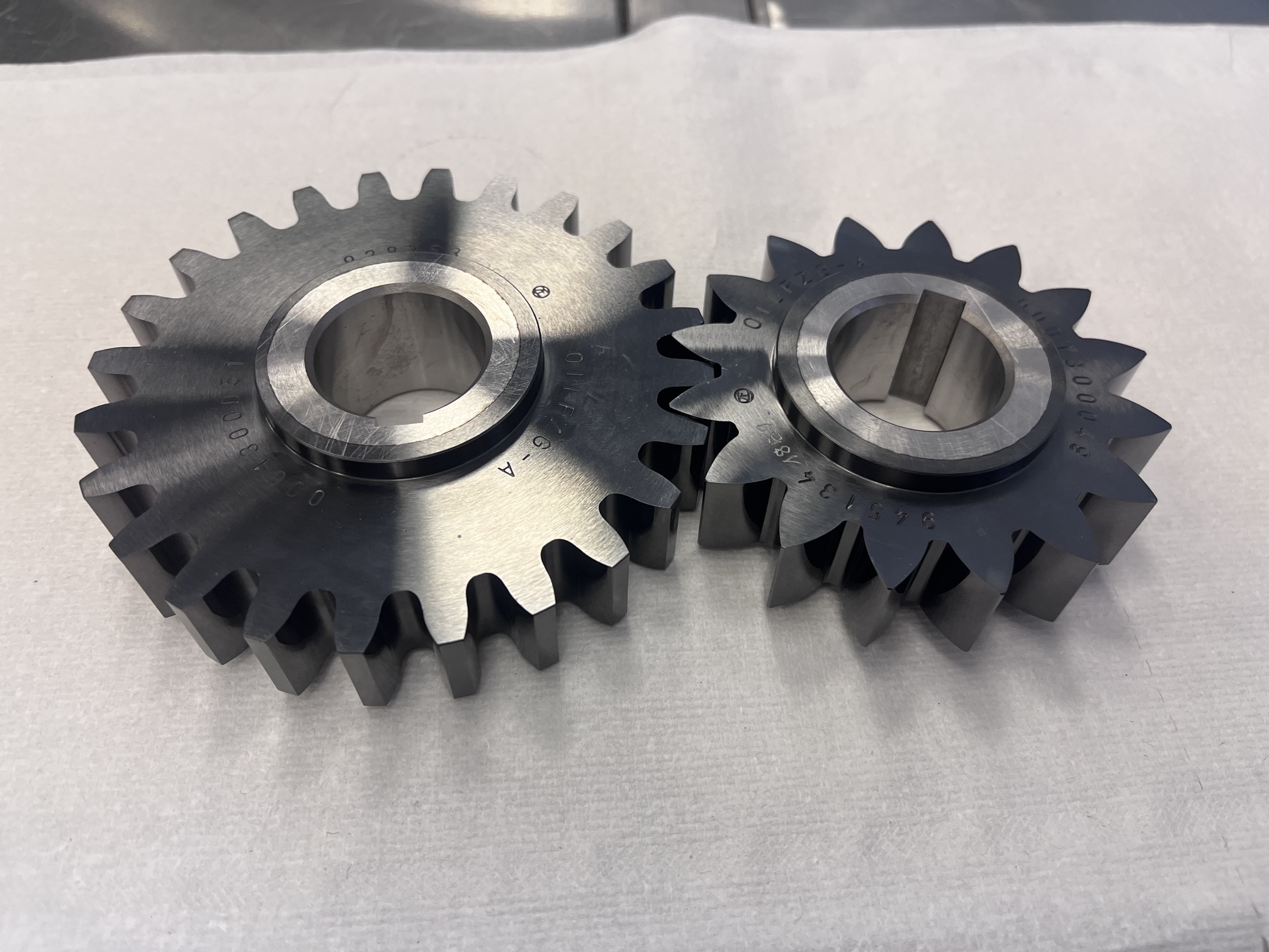 Two metal gears with dark faces and machined central bores